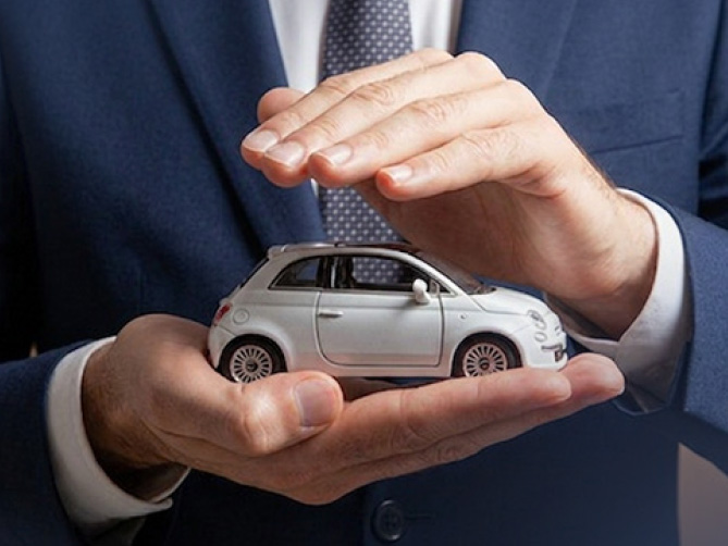 Mani che proteggono un modellino di auto